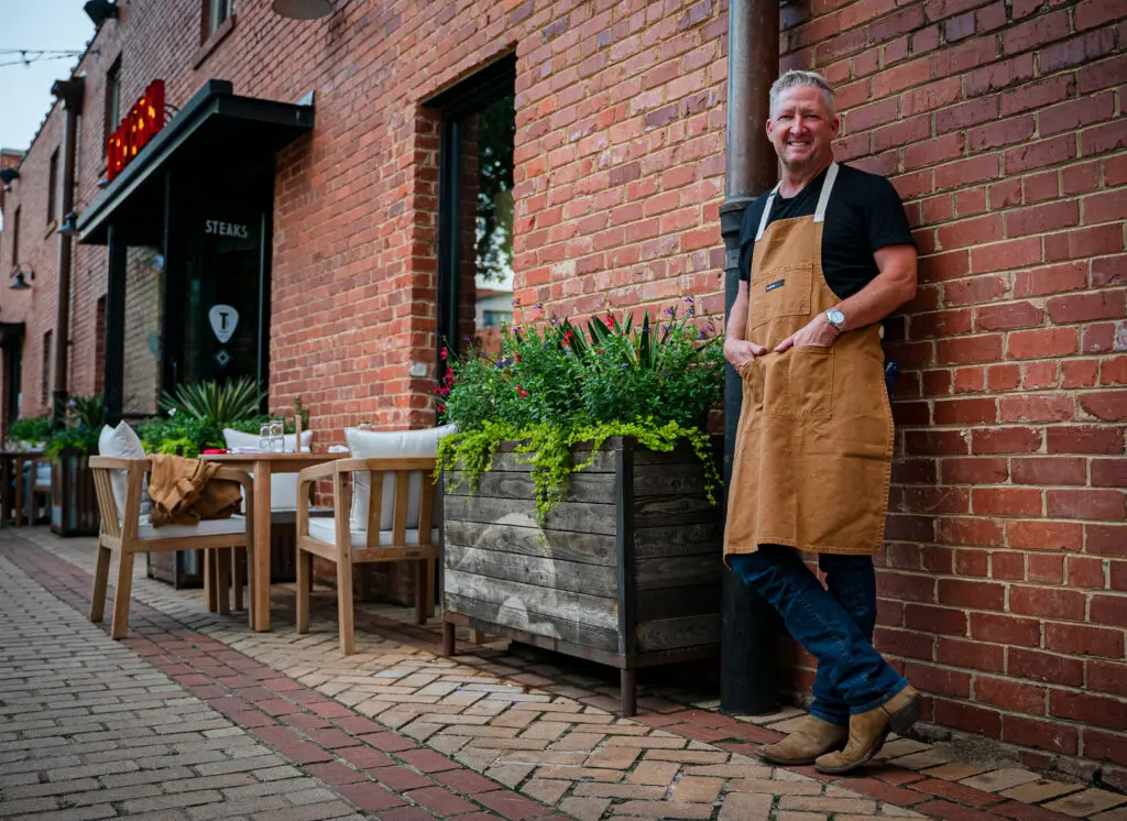 Tim Love modeling the chef's apron, proof he still cooks from time to time. (Photo by Daniel Hooks)