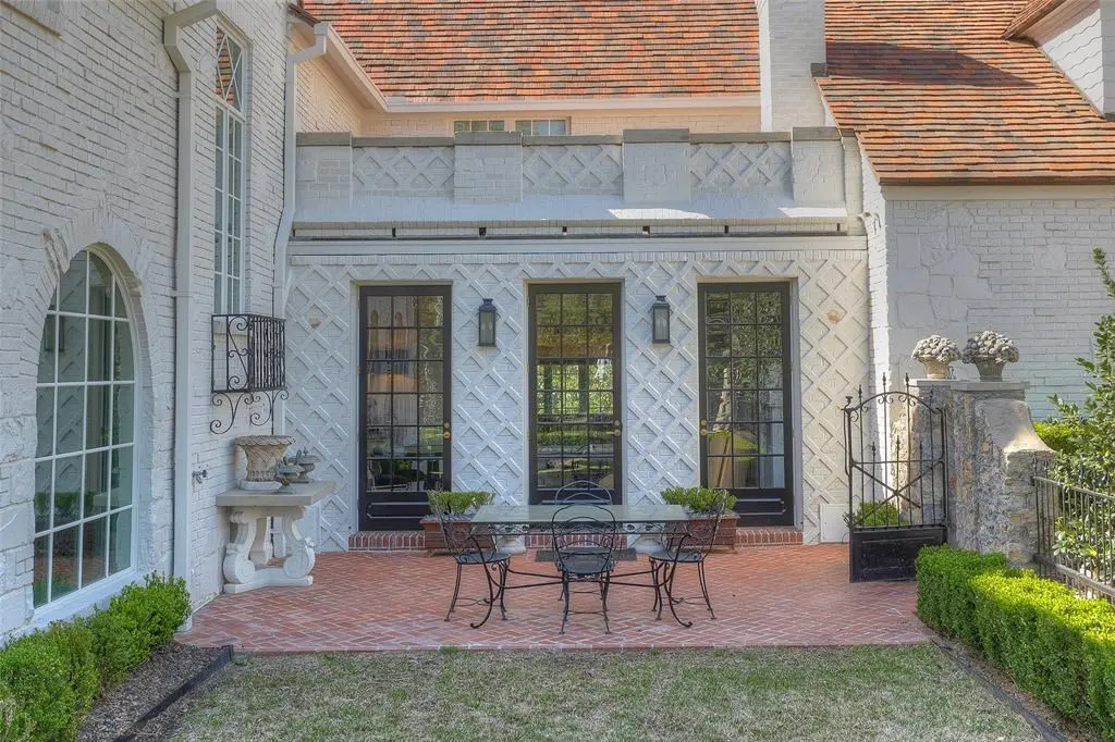 The home's brick and stone facade were painted white. Here the upstairs balcony overlooks one of the home's patios.