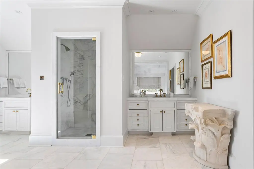 The master bath clad in white marble keeps it clean and spa like.