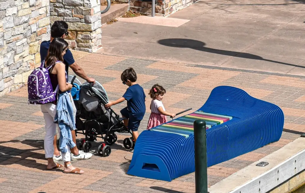 Public art in The Woodlands proves to be not only beautiful but also interactive as a young girl plays on a musical bench. (Photo by Jessica T. Payne) 

