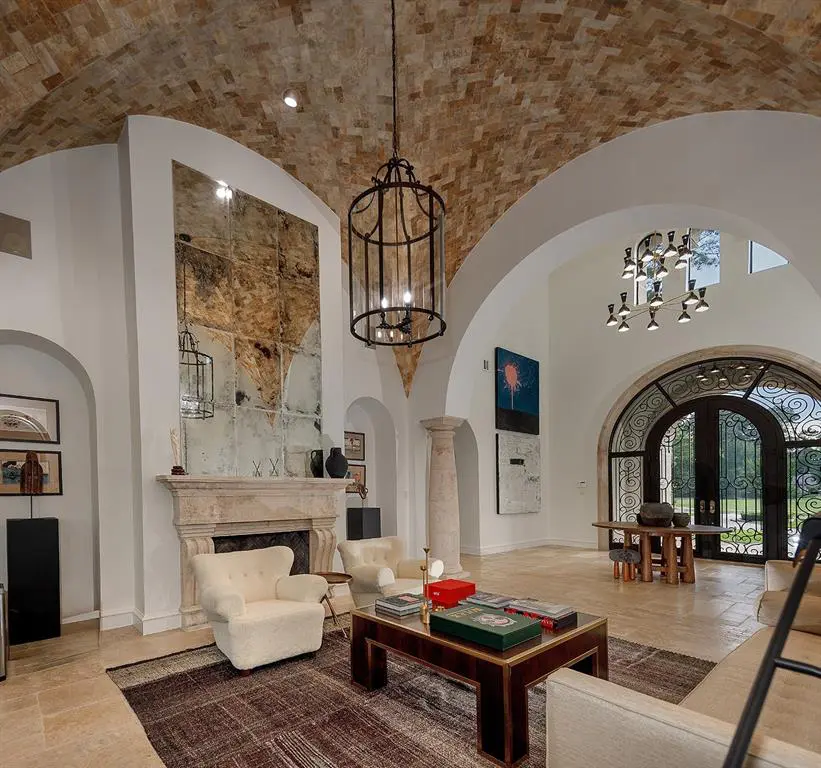 Features of the formal sitting room in this Woodlands mansion include stone groin vault ceilings and custom-made chandeliers.