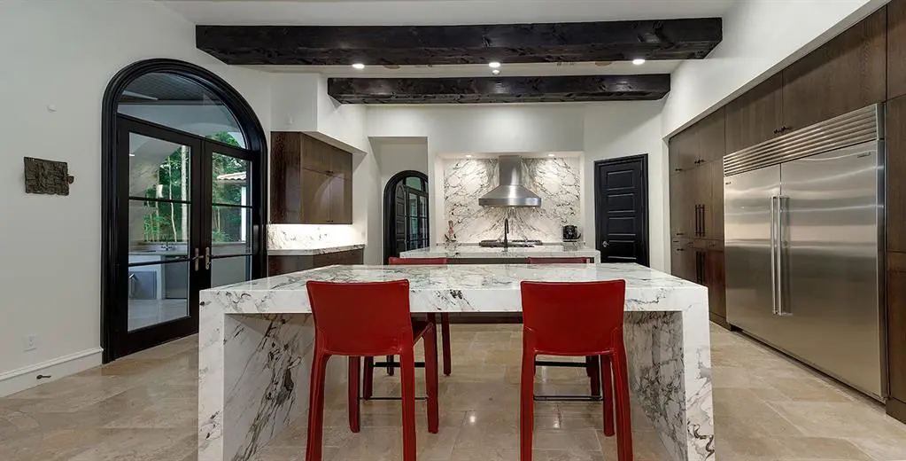 Wooden beams and warm-white marble counters perfectly complement the kitchen aesthetic. 