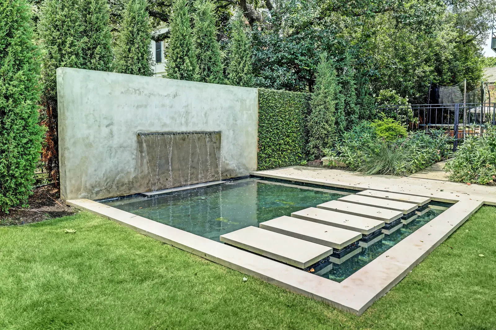 The spacious side yard at 3404 Chevy Chase features a water feature that captures attention. (Photo by TK Images)