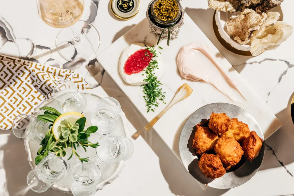 The caviar selections at Little's Oyster Bar are served with fried potato dumplings, radish butter, crème fraiche, onion jam, and chives. (Photo by Arturo Olmos)