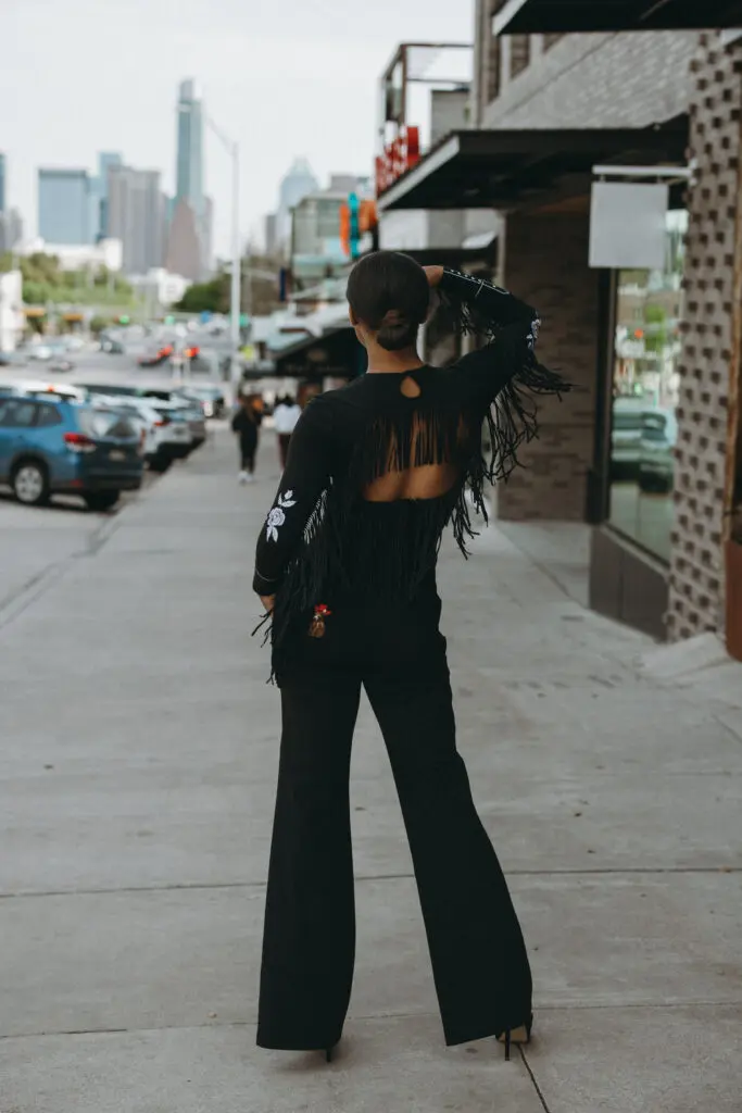 Fringy Baby was inspired by an open back gown with fringe lining the back and arms. The flower detailing is inspired by Lee's mothers’ original rodeo jacket. 