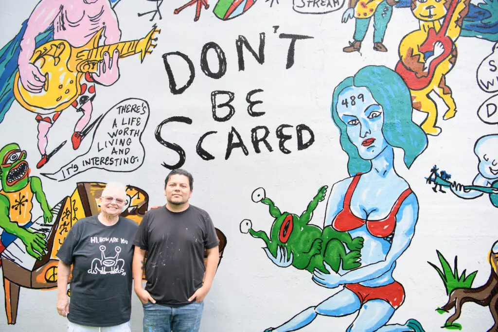 Marjory Johnston, artist Carlos Alcaraz (Empyre) at the "Don't Be Scared" mural at Redbud Arts Center (Photo by Saranna Zhang/Kevin Zhang Photography)