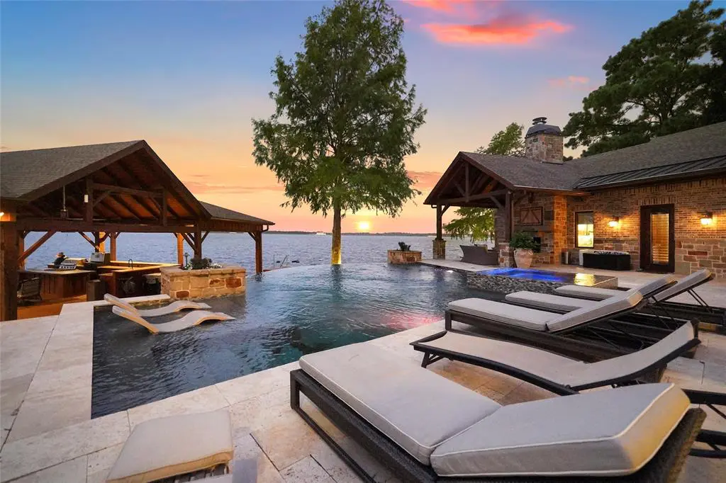 The lakefront home at 9144 Escondido Drive features a salt water infinity pool. (Photo by EmoMedia/Compass)