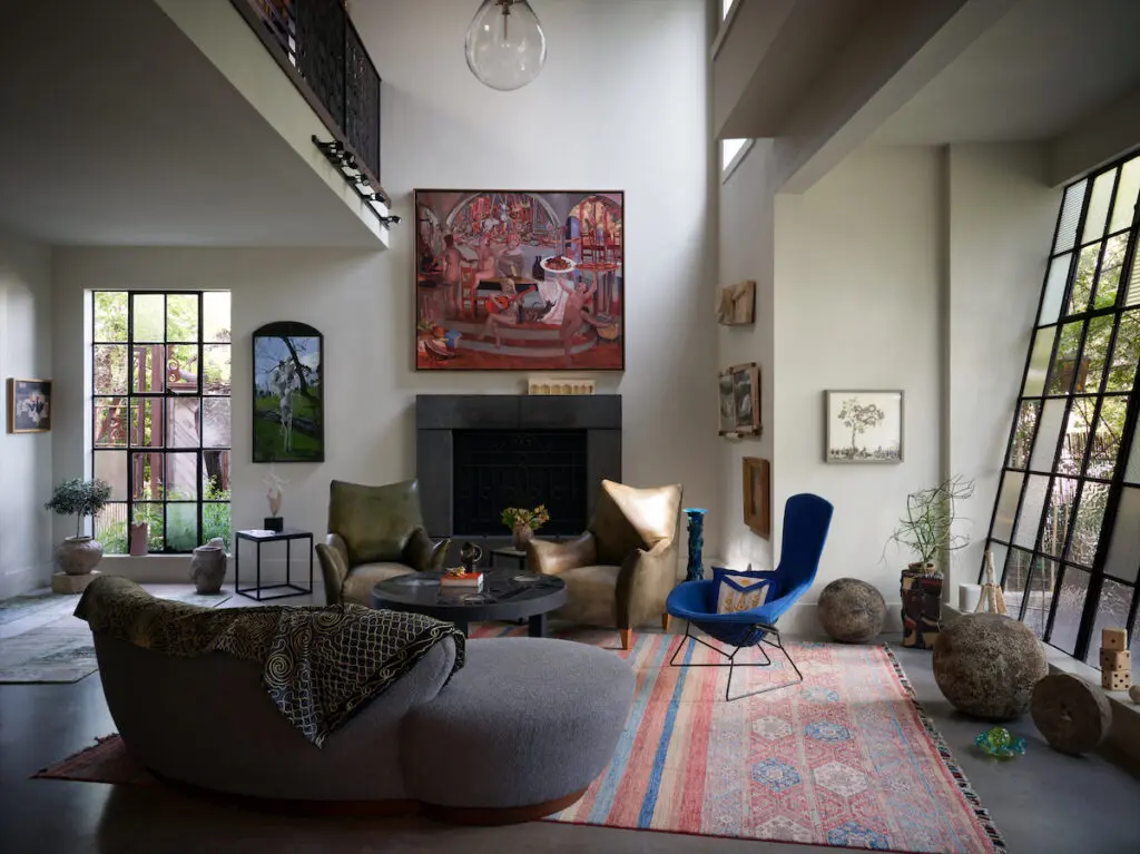 In the Tower House living room, an old metal window is slanted towards the garden view. Paintings by Barnaby Fitzgerald and Miles Cleveland Goodwin, from Valley House Gallery
& Sculpture Garden. Vintage ‘50s-era Bertoia Bird chair and Vladimir Kagan sofa from Collage. Vintage Turkish wedding rug. (Photo by Pär Bengtsson)