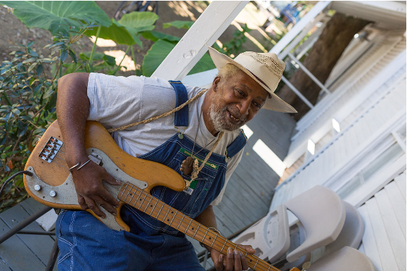 Jesse Lott strums the electric bass guitar. (Photo by Alex Barber, courtesy Project Row Houses, Houston)