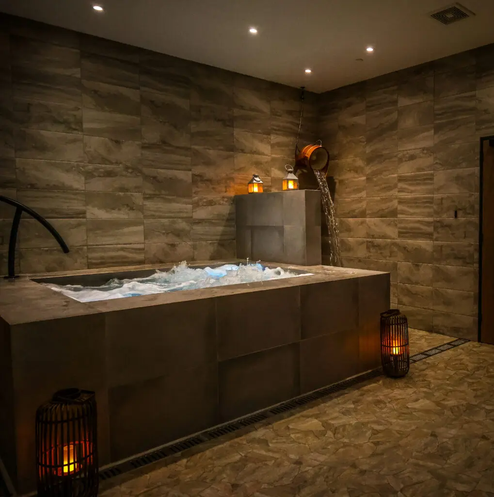 Resort-style amenities include the complimentary coed wet room. There, guests can soak and unwind those tense muscles in a bubbling 12-person hot tub, step into the eucalyptus-scented steam-filled dry sauna, then jump from hot to cold and experience a refreshing splash of contrast bathing with a simple pull of a rope. (Photo by Courtesy of Escape Spa)