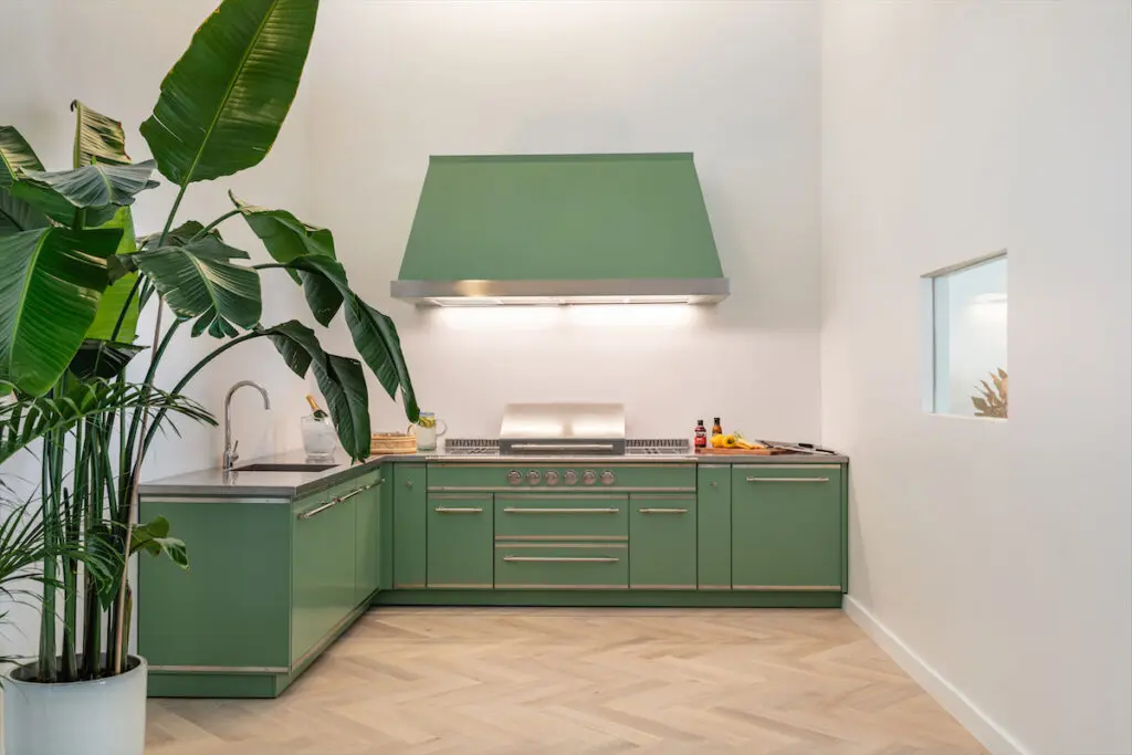 A custom outdoor cooking suite at the Dallas L'Atelier Paris showroom features a professional lava rock BBQ.