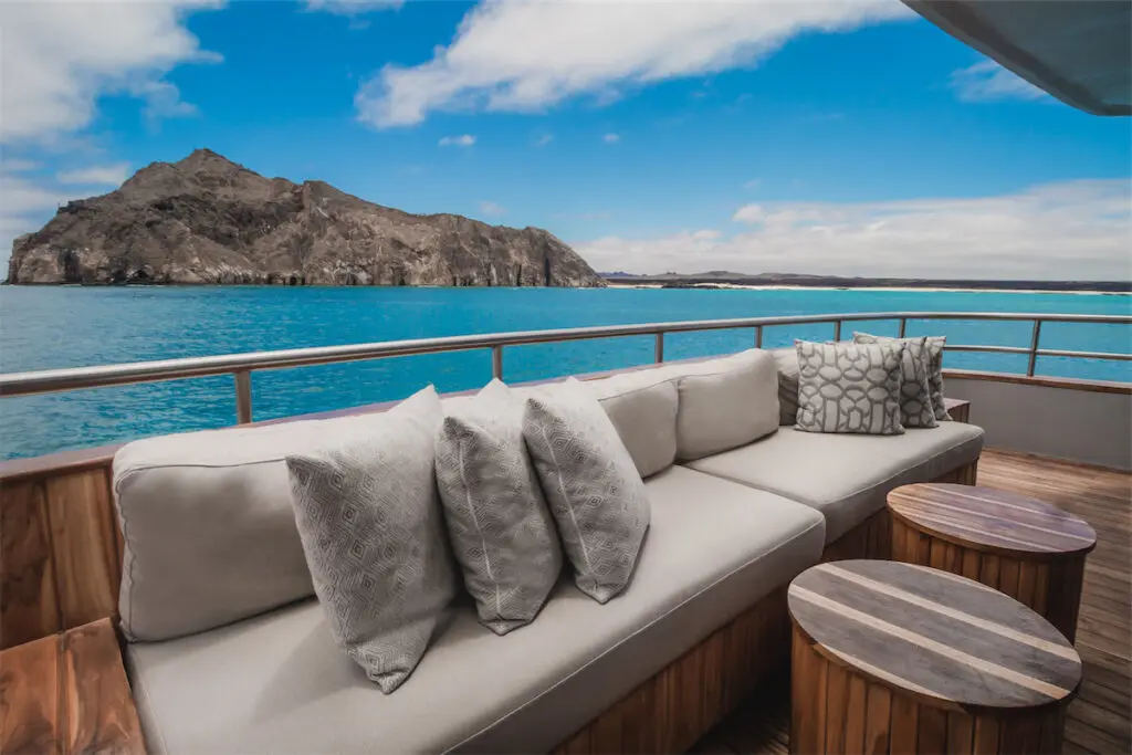 The top deck is partially shaded and fashioned with day beds, hammocks, an outdoor shower, and wet bar. 