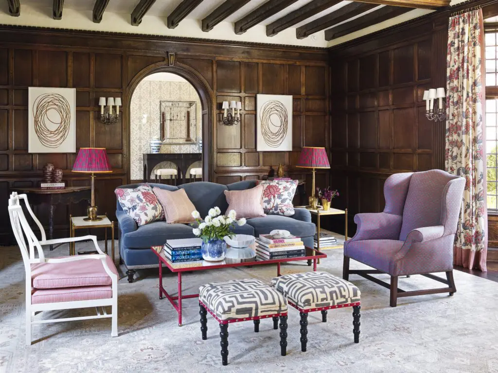 Traditional shapes and forms enlivened with bright, bold colors and patterns make an impact within dark oak surroundings, in a room designed by Carrier and Company. The oversize antique Chippendale chair
stands out in its updated lacquer finish. Artwork flanking the doorway is by Neal Perbix. (Photo by Annie Schlechter) 