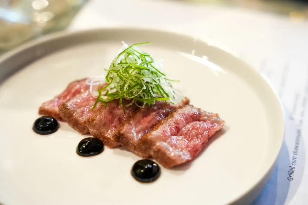 A5 wagyu with a date and balsamic reduction and wasabi salt is the seventh course at Hando's omakase at The Kanpai Club. Photo by Michael Ma.