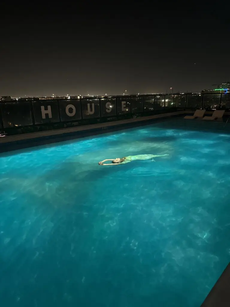 A swimmer floats in the water alongside a projection of herself at the "Surface Tension" reception. (Photo by Haley Berkman Karren) 