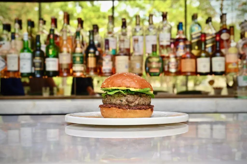 Chef Botero is of the mind that every bar menu should have a burger and Le Jardinier's features a diminutive lamb burger served on a fluffy brioche-like bun with melted gruyere cheese, date jam, and topped with turmeric golden yellow-tinged Vadouvan aioli. (Photo by Alex Montoya)