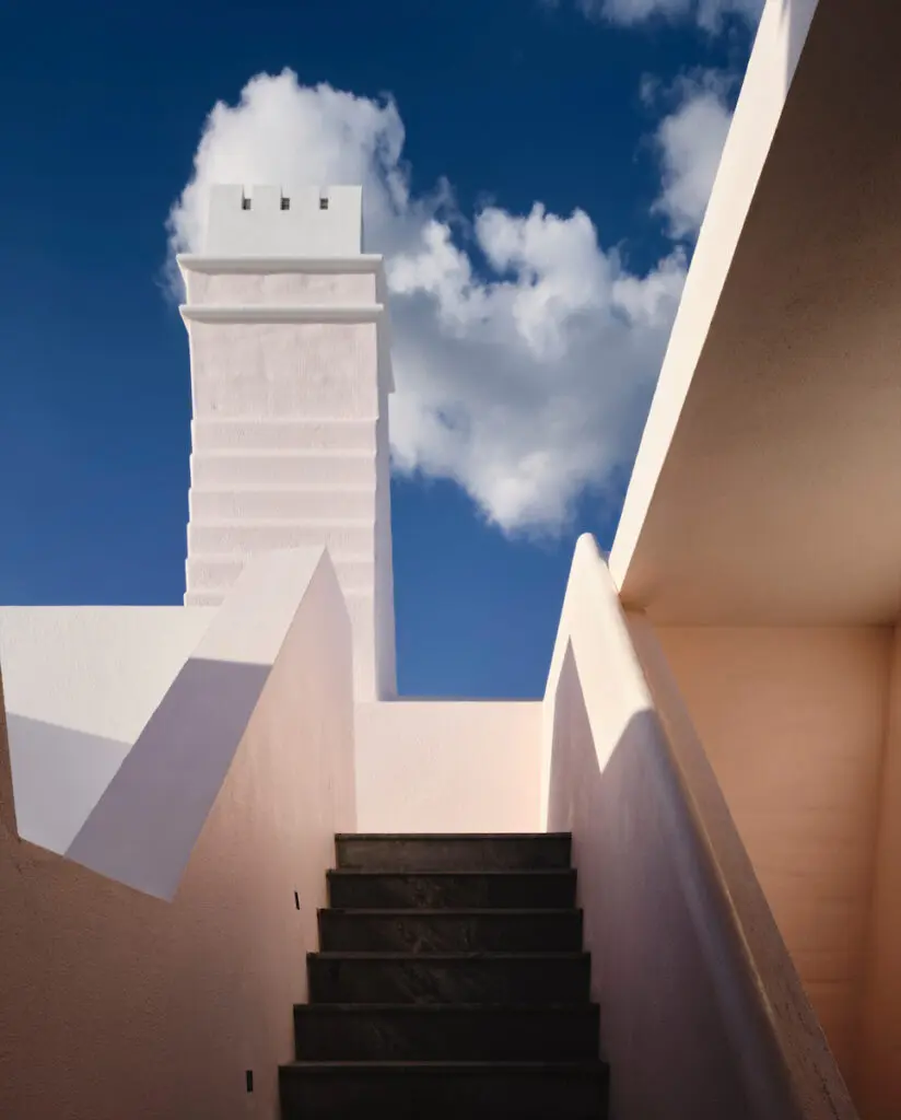 Designed by OBMI architect Colin Campbell, the island house’s pink plaster exterior turns almost white in the intense sunlight. A chimney is used for ventilation. The staircase leads to an upper-deck pavilion. (Photo by Douglas Friedman)