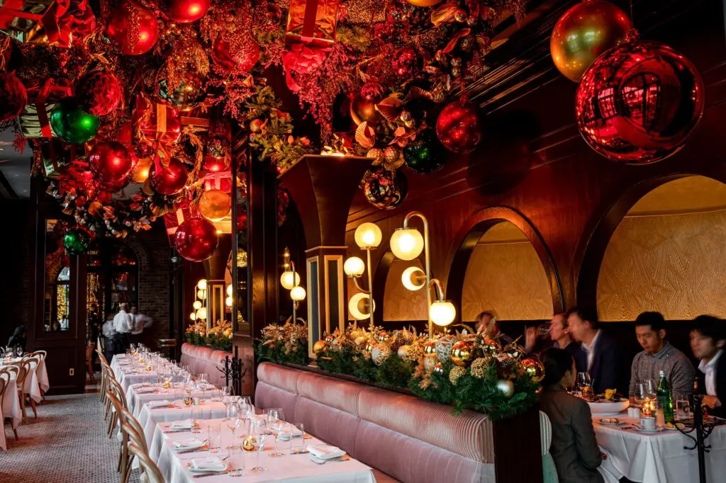 The room at Annabelle Brasserie is appointed with back-to-back banquettes upholstered in blush-pink fabrics opposite bentwood chairs. Along the interior perimeter, domed opera booths with demi-lune tables make for a perfect tête-à-tête. (Photo by Kristen Gilliam)
