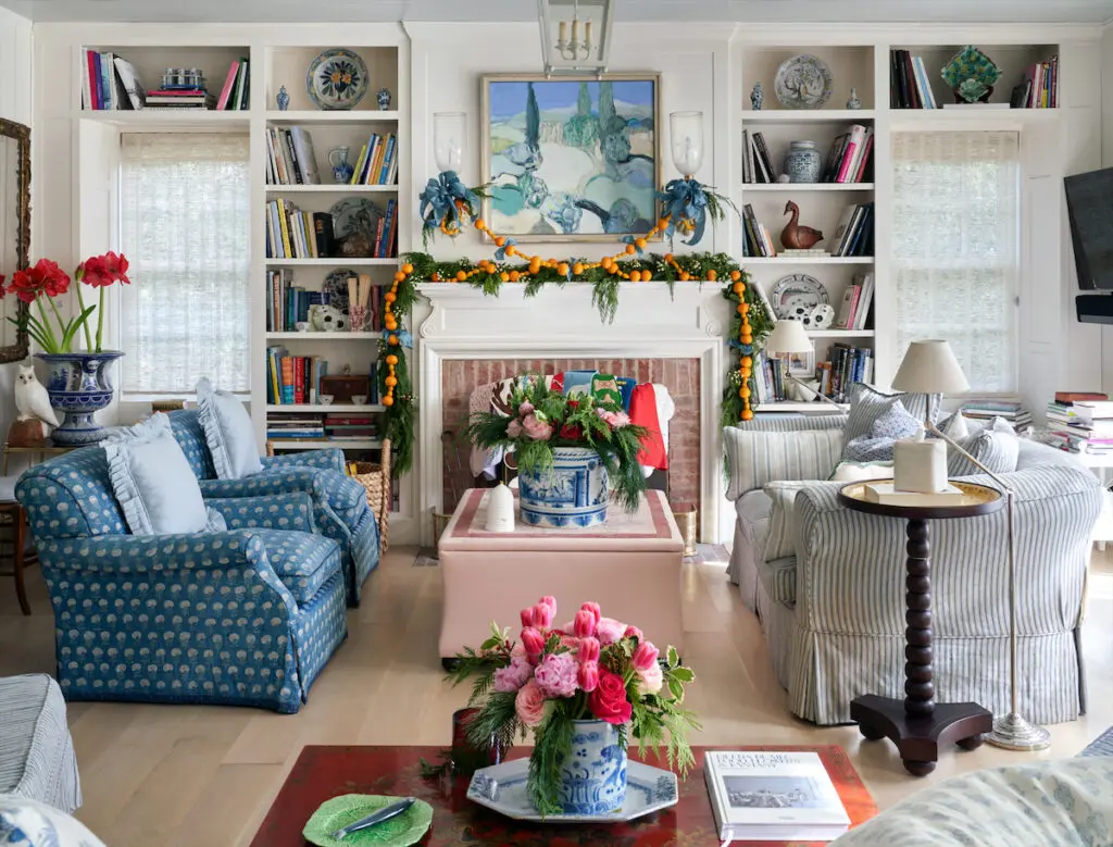 In the family room, chairs and sofa are covered in Colefax and Fowler and Elizabeth Eakins fabrics. Pink peonies and tulips paired with pine fronds in Chinese blue-and-white pots. (Photo by Pär Bengtsson)