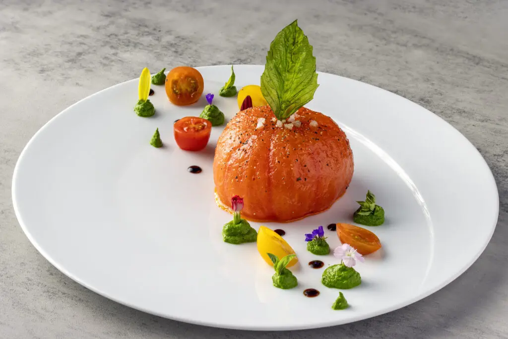 Cocody plays up the classic combination of tomato and burrata cheese, blanching a whole tomato, peeling it, and filling its cavity with imported Italian burrata, a sliver of tomato (sun-dried to concentrate its flavor), and adorned the plate with fried basil leaves, heirloom cherry tomatoes, and dollops of basil pesto ($19). (Photo by Mickael Zibi )