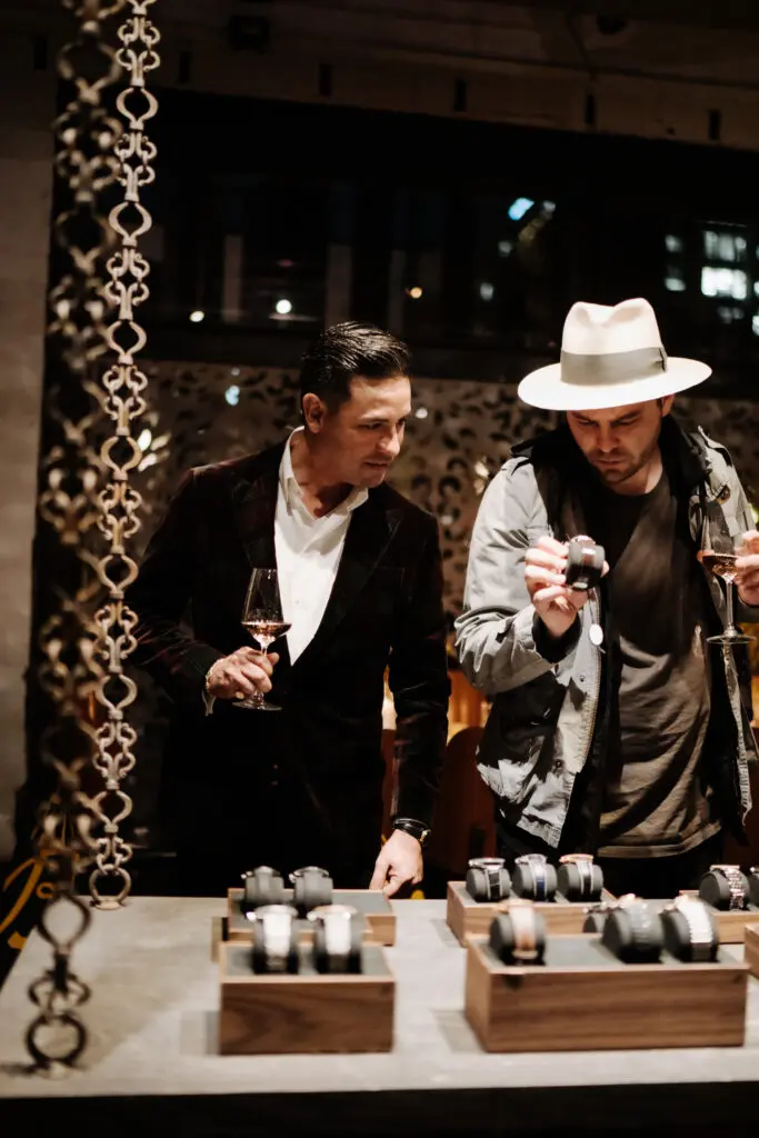 Dinner guests perusing the watches that had been brought to Grange Hall for ooh'ing and ah'ing ... and purchasing.  (Photo by Afritina Coker)