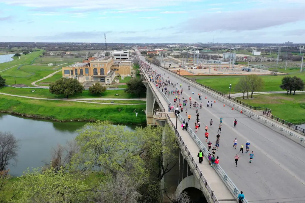 Photo of runners traversing the Northside bridge during the Cowtown Marathon. (Photo by Brian Luenser)