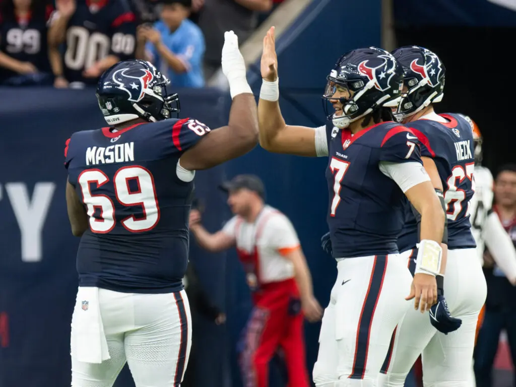 Houston Texans quarterback C.J. Stroud has a high five for everyone, including right guard Shaq Mason. (Photo by F. Carter Smith)