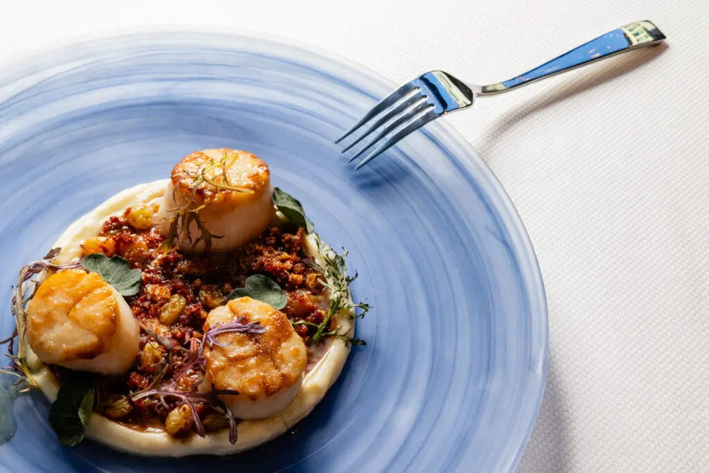 Seared scallops rest atop clery root puree with smoked trout roe. (Courtesy photo)