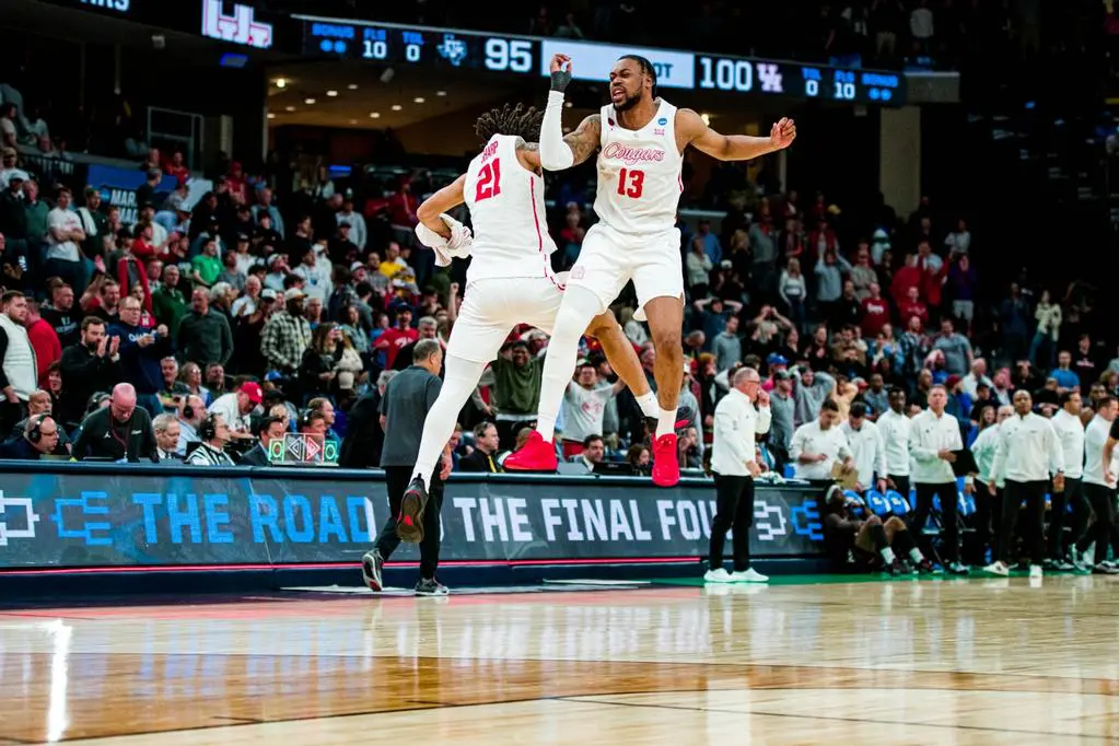 When you win an NCAA Tournament that is this epic, you'd better jump into the air like Houston players Emanuel Sharp and J'Wan Roberts do. (Photo by Matthew A. Smith, courtesy UH athletics).