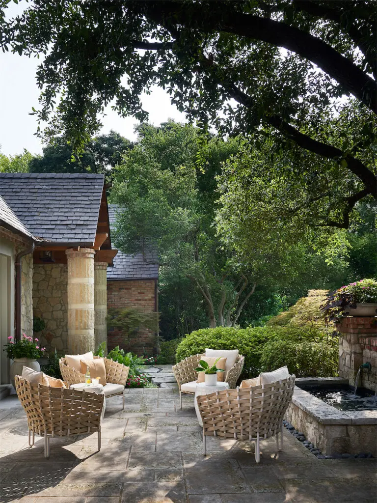 A back terrace features Dilbeck’s signature use of stone, brick, columns, and slate rooftops. (Photo by Stephen Karlisch)