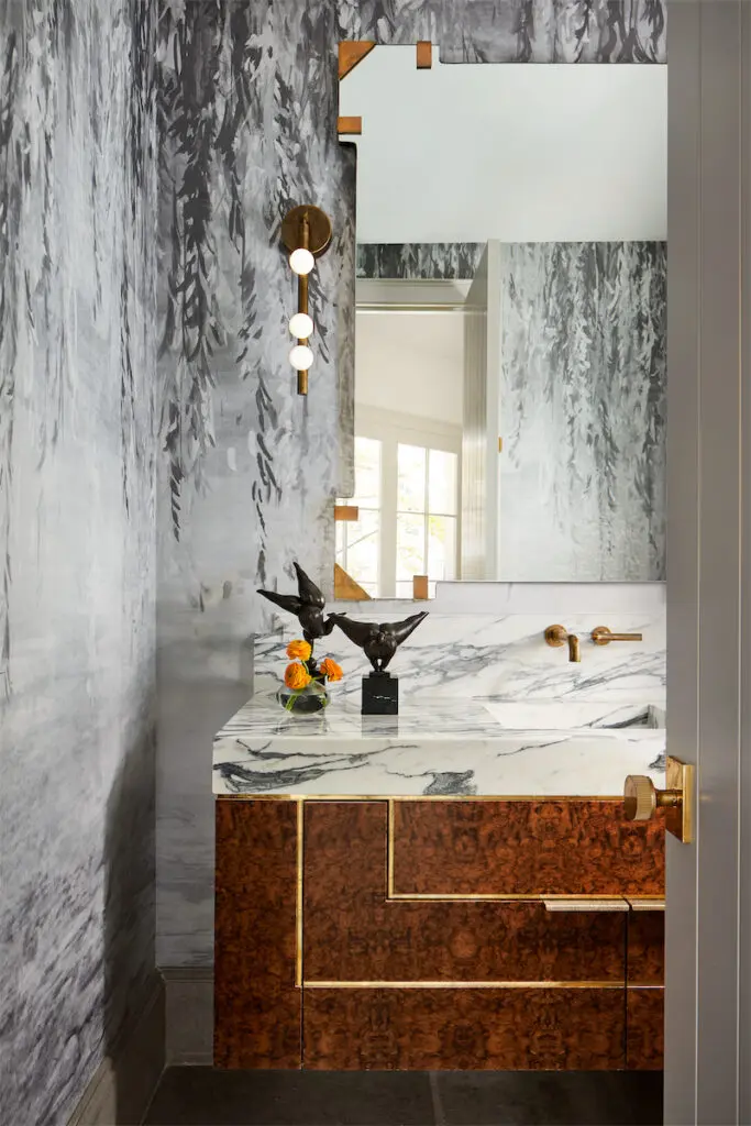 In a powder bath, wallpaper by Phillip Jeffries, Lindsey Adelman sconce, and custom sink. (Photo by Stephen Karlisch)
