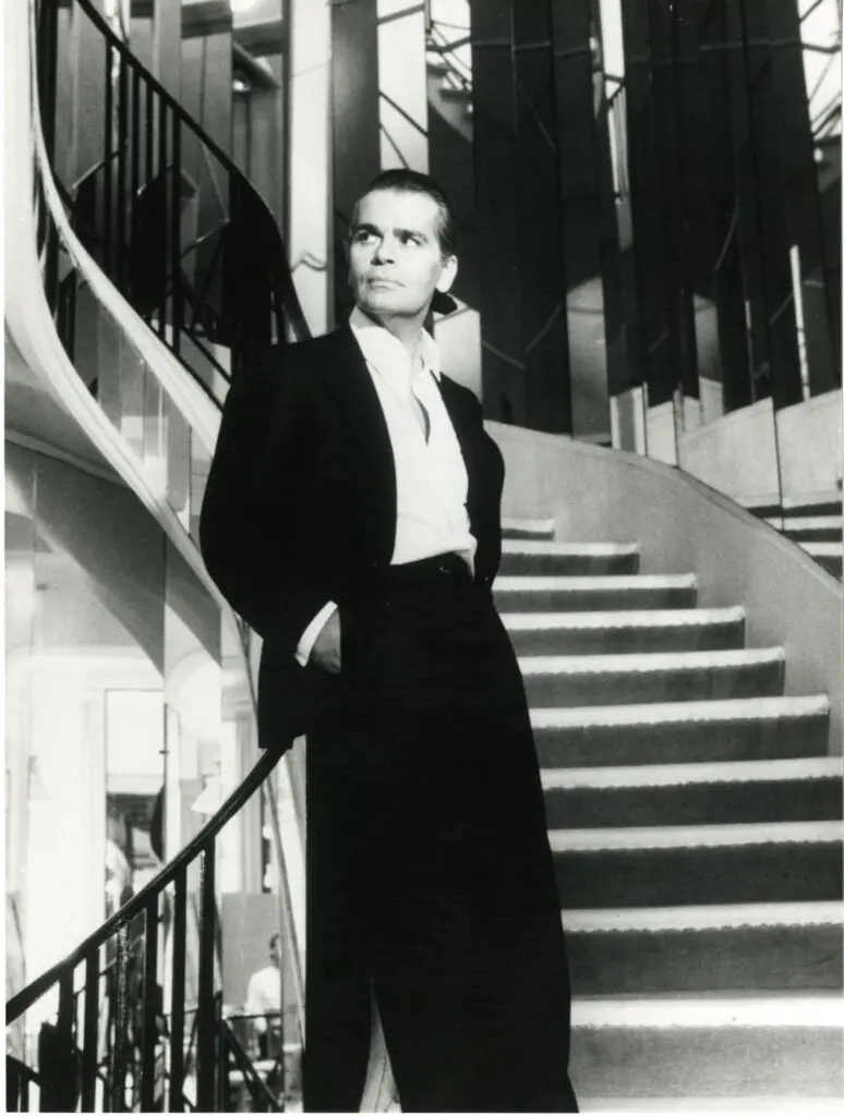 January 1983, Karl Lagerfeld is named artistic director of Chanel, and is immortalized by Helmut Newton on the mirrored staircase at 31, rue Cambon where Gabrielle Chanel once perched. (Courtesy Patrimoine de CHANEL, Paris; © The Helmut Newton Foundation)