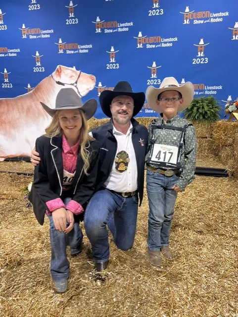 Tony Bradfield with to youngsters who had steers in the 2023 Junior Market Steer Auction at RodeoHouston