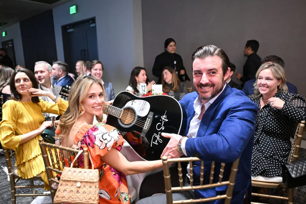 Chea & Lia Kelly with the Taylor Swift autographed guitar that they made the winning bid on at the Houston Classical Charter School gala. (Photo by Daniel Ortiz)