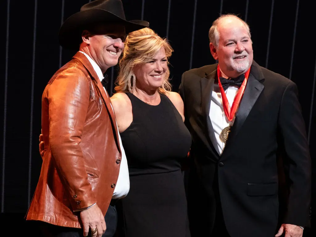 Wearing Kenny Rogers' leather jacket, associate vice president for alumni relations Mike Pede and Kenny Rogers' uncle and his wife honor the country music legend with UH ties. (Photo by F. Carter Smith)