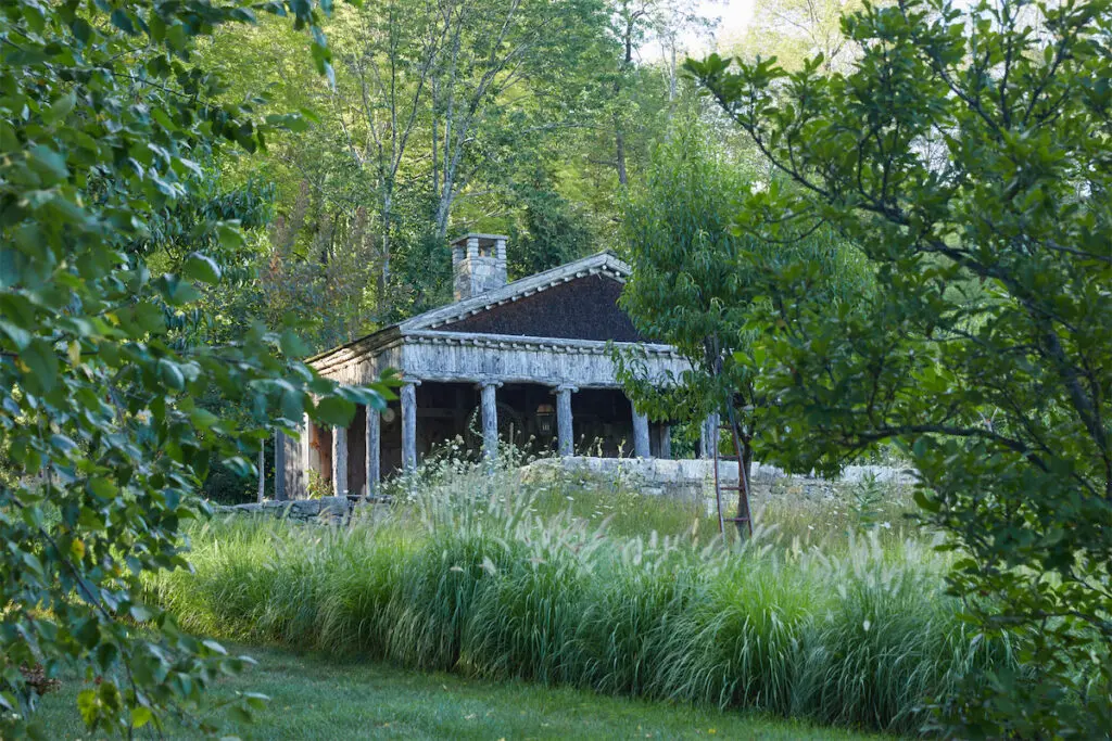 The idea for the pool house’s weathered Greek temple architecture came from an 18th century book on garden follies that Williams discovered in France. (Photo by Annie Schlechter)