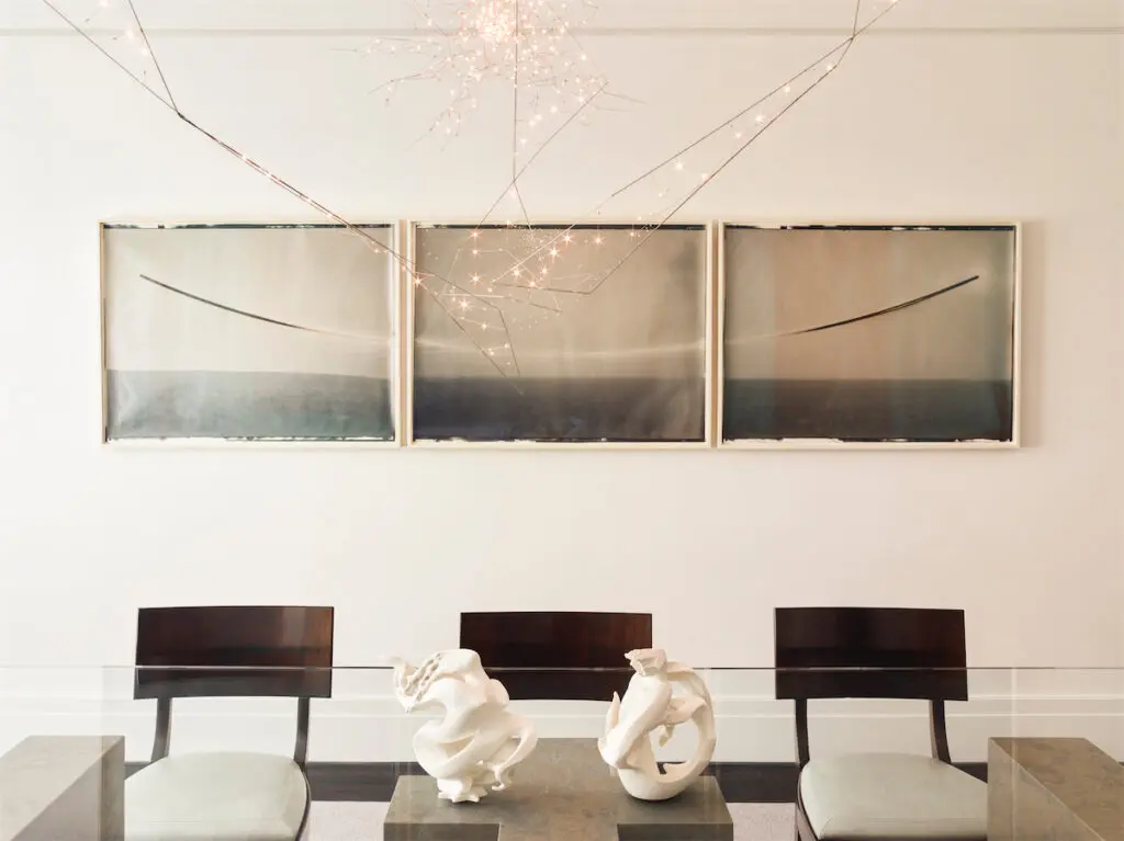 Kaj Gottlob vintage Danish dining chairs in Jerry Pair leather. Custom light fixture, Bastien Carré. Chris McCaw triptych. On table, vintage Sèvres porcelain sculptures. (Photo by Eric Piasecki)