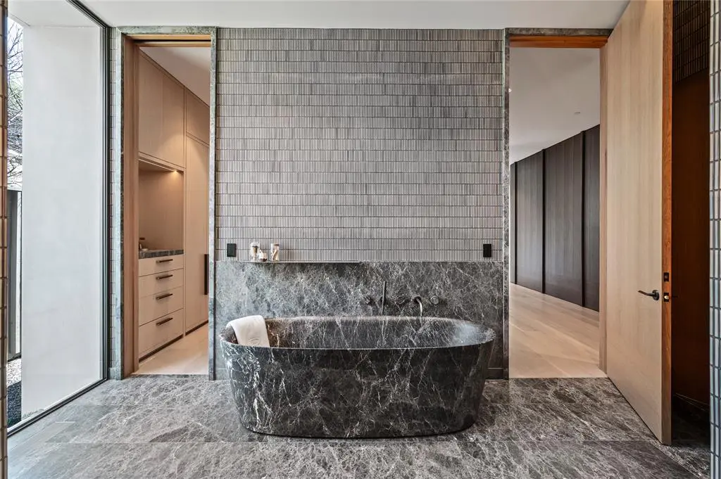 The primary bathroom suite with a view of a closet. 