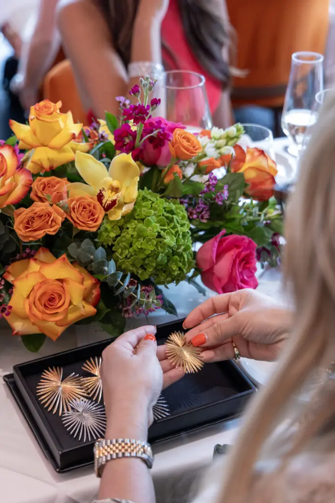 Guests try on earrings from the Giorgio B's Palma collection at the de Boulle Diamond & Jewelry lunch at Bari (Photo by Jordan Geibel)