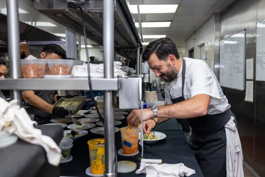 Chef Aaron Bludorn putting finishing touches on his dish at the Houston Ballet 'Raising the Barre' dinner at Caracol. (Photo by Melissa Taylor)