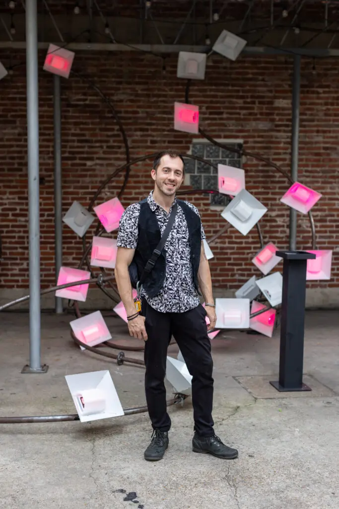 Boston Kassidy of Moon Papas Art in front of the group's interactive sculpture at the 2024 Glasstire Party and Auction (Photo by Jenny Antill) 