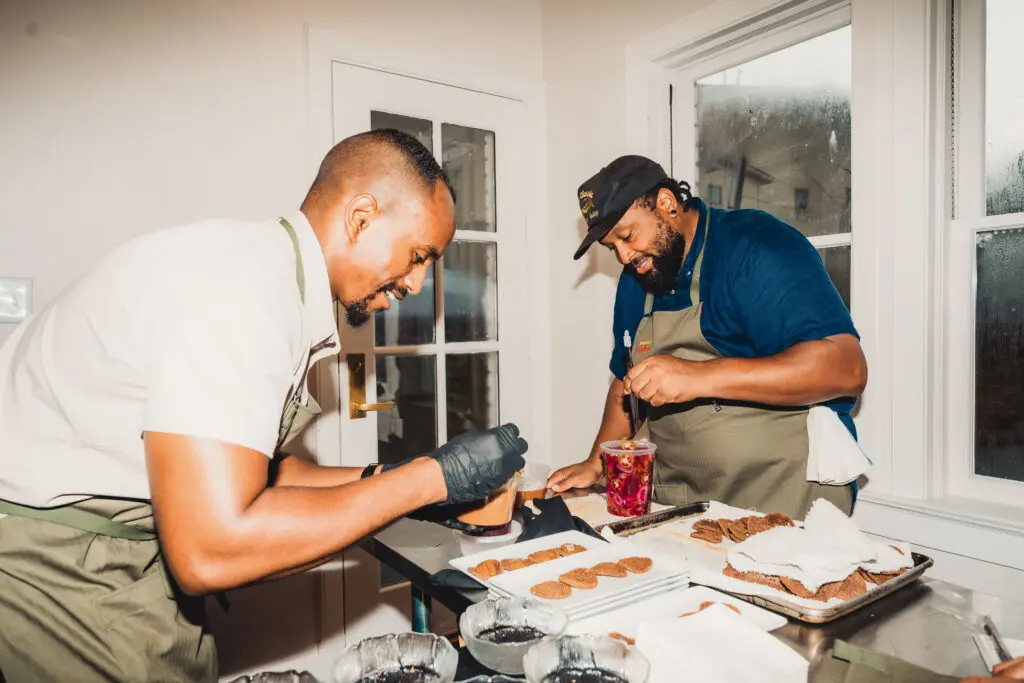 Chefs Khalieb Rufael and Joseph Boudreaux plate Injera Crisp, Whipped Shiro, and Fresh Pepper at the Juneteenth Jubilee dinner.