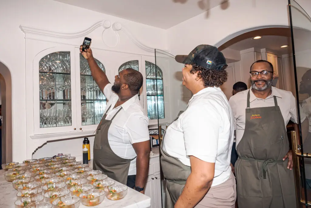 Chefs Tristen Epps. Anitra Broussard, and Lawrence Walker pose for a selfie at the Juneteenth Jubilee dinner.