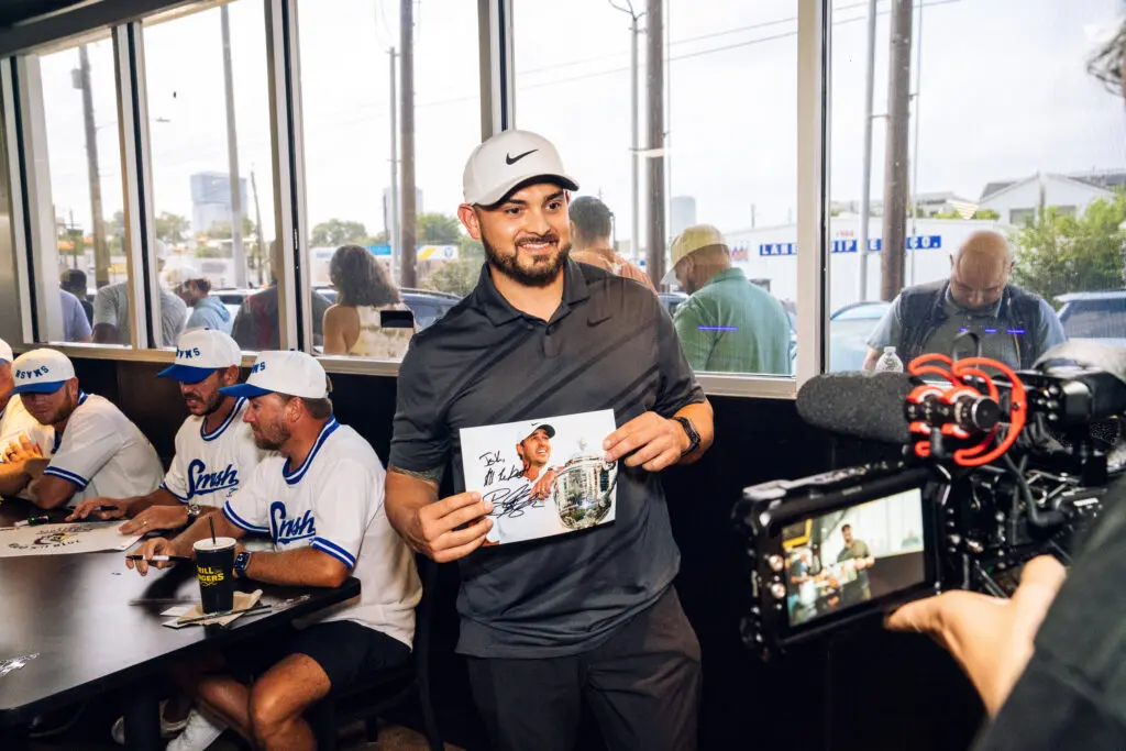 This fan proudly showed off his Brooks Koepka signed poster. (Photo by Dylan McEwan)