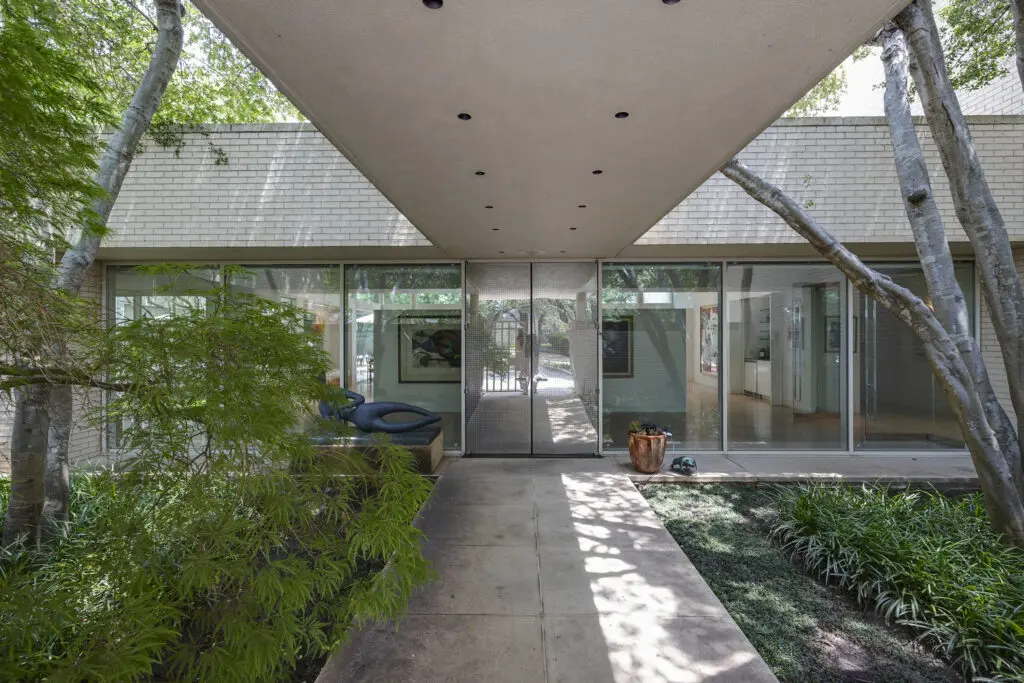 At 3950 Sarita Park Court, the mirrored front door leads to walls of windows and flowing spaces.