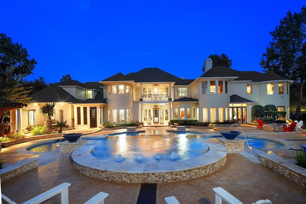 The backyard retreat is perfect for entertaining guests with a large swimming pool, patio seating, and a guest house. 