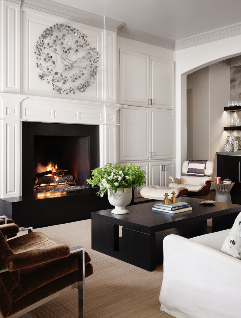 In the family room, a pair of vintage mohair armchairs by Milo Baughman, Holly Hunt coffee table, Eames lounge chair and ottoman from DWR, Warren Platner side table, vintage C. Jeré wall sculpture from 1stdibs.  (Photo by Lisa Petrole)