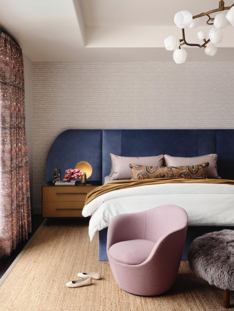 In the main bedroom, the headboard is custom. Peacock Alley bedding, bolster in Designers Guild Uchiwa fabric. Croft House nightstands. Handira wallcovering from David Sutherland Showroom. Lina swivel chair from DWR, Lawson-Fenning ottoman. Willie Weston drapery fabric from Supply. Apparatus chandelier from Garde. (Photo by Lisa Petrole)