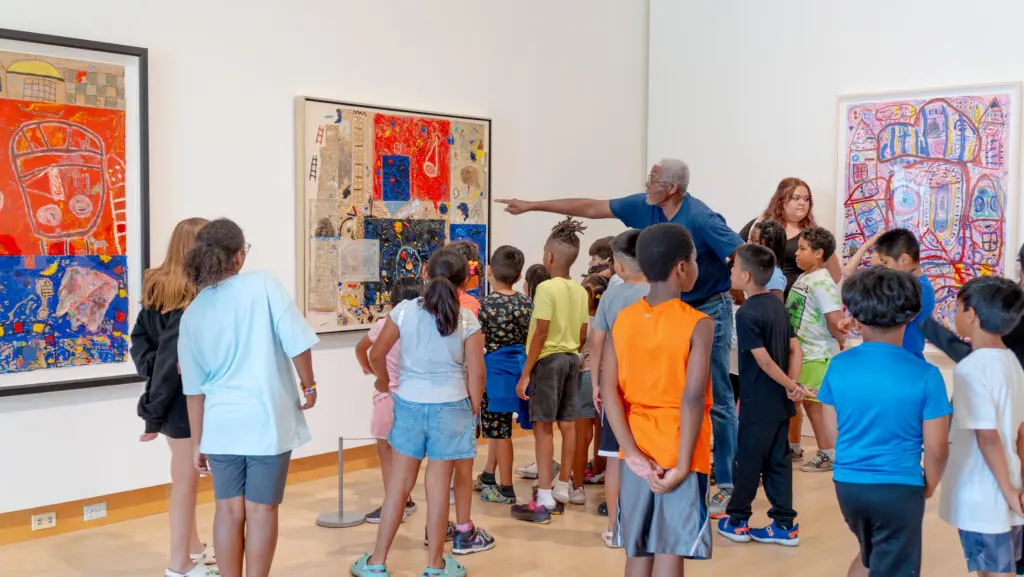 Floyd Newsum discusses his artwork with young visitors at the Madison Museum of Contemporary Art in conjunction with his 2023 solo retrospective, "Evolution of Sight." (Courtesy MMoCA)