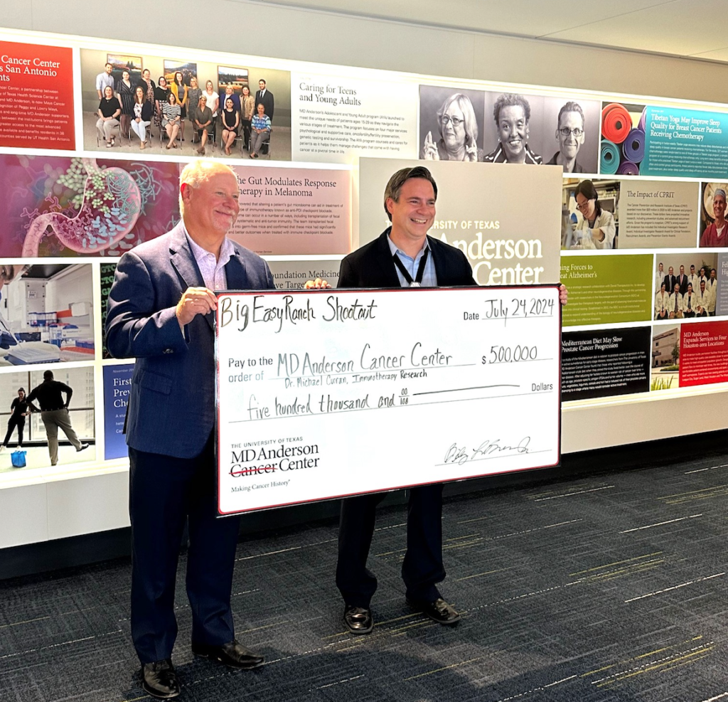 Big Easy Ranch owner Billy Brown presents the check to Dr. Michael Curran of MD Anderson's Department of Immunology. 
